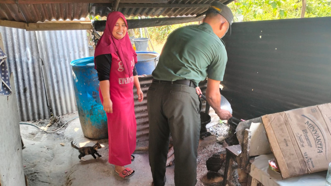 Serda Holmes Pasaribu Babinsa Koramil 03/Minas Bentu Warga Dengan Masuk Dapur Ibu Nurhayati Warga Kurang Mampu di Muara Kelantan