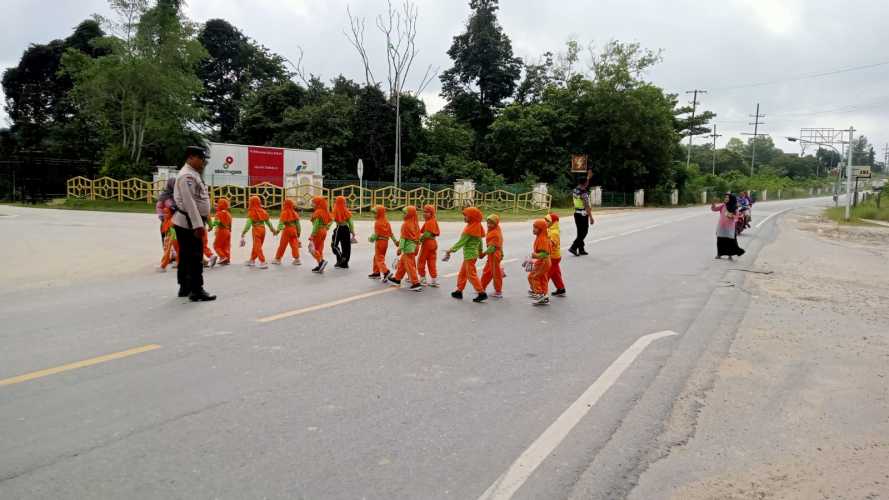 Bentuk Kepedulian Polri Kepada Masyarakat, Kapolsek Minas Kompol Sawaluddin Pane SH Bantu Anak-anak Sekolah Menyebrangi Jalan Raya